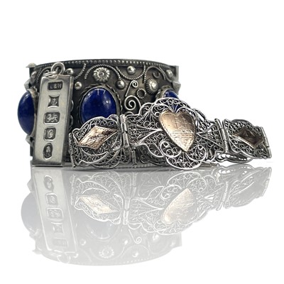 Lot 256 - An eastern white metal hinged bangle set with...