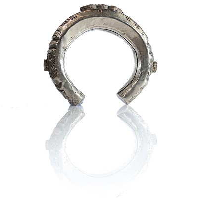Lot 274 - A tribal white metal lapis lazuli set bangle.