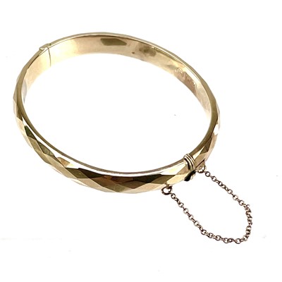 Lot 24 - A continental yellow metal hollow hinged bangle.