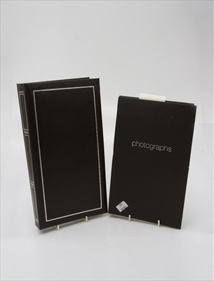 Lot 557 - Postcards. Two photograph albums containing...
