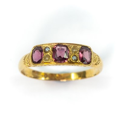 Lot 113 - An early 20th century 15ct garnet and seed pearl set ring.