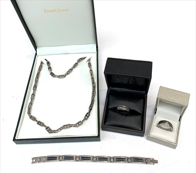 Lot 2434 - Two titanium rings each set with a diamond and...