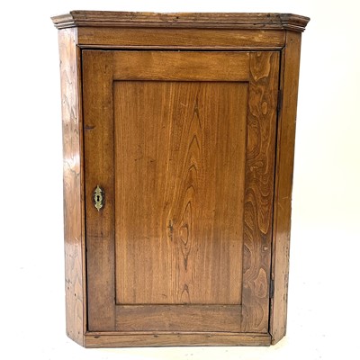 Lot 44 - A George III oak hanging corner cupboard.