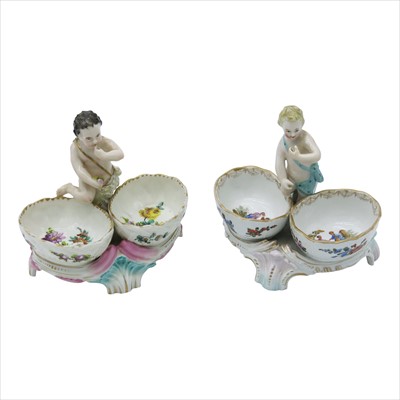Lot 1392 - Two Dresden double salts surmounted by cherubs,...