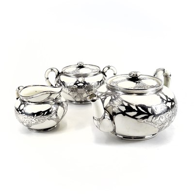 Lot 872 - A Royal Doulton white glazed silver overlaid three-piece tea service.