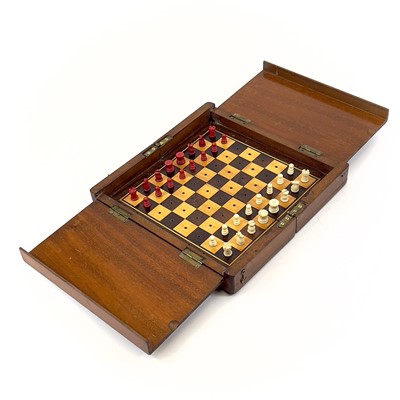 Lot 124 - A mahogany folding travel chess set.
