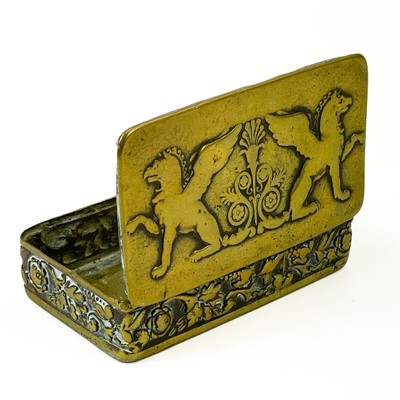 Lot 37 - An 18th century brass snuff box with repousse Griffins and foliate frieze panel.
