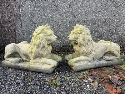 Lot 603 - A pair of reconstituted stone recumbent lions.