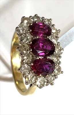 Lot 2510 - An 18ct ruby and diamond triple cluster ring.