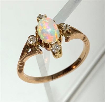Lot 2425 - A gold ring with a central oval opal within...