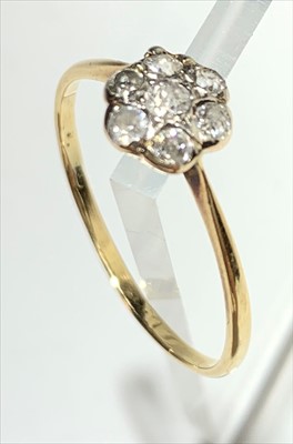 Lot 2424 - A diamond daisy cluster gold ring.