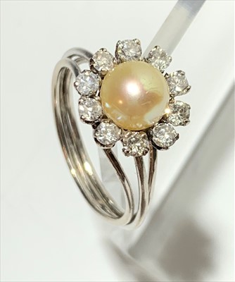 Lot 2431 - An 18ct. white gold ring with a flower-head...