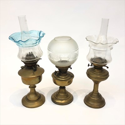 Lot 330 - A group of three brass oil lamps, shades and...