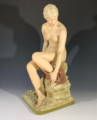 Lot 1453 - A Royal Dux type porcelain figure of a seated...