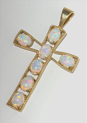 Lot 2562 - A 9ct cross set seven opals, length 5.1cm.
