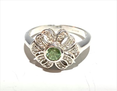 Lot 2576 - A diamond and peridot bow set white gold ring.