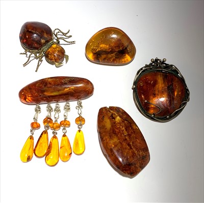 Lot 2560 - Five amber brooches, the largest 5.8 x 3.3cm.