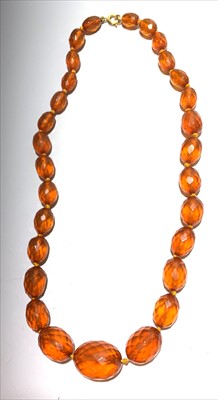 Lot 2621 - A graduated faceted amber bead necklace,...