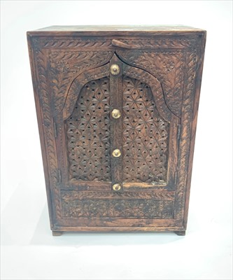 Lot 3300 - An Indian carved hardwood cupboard, with a...